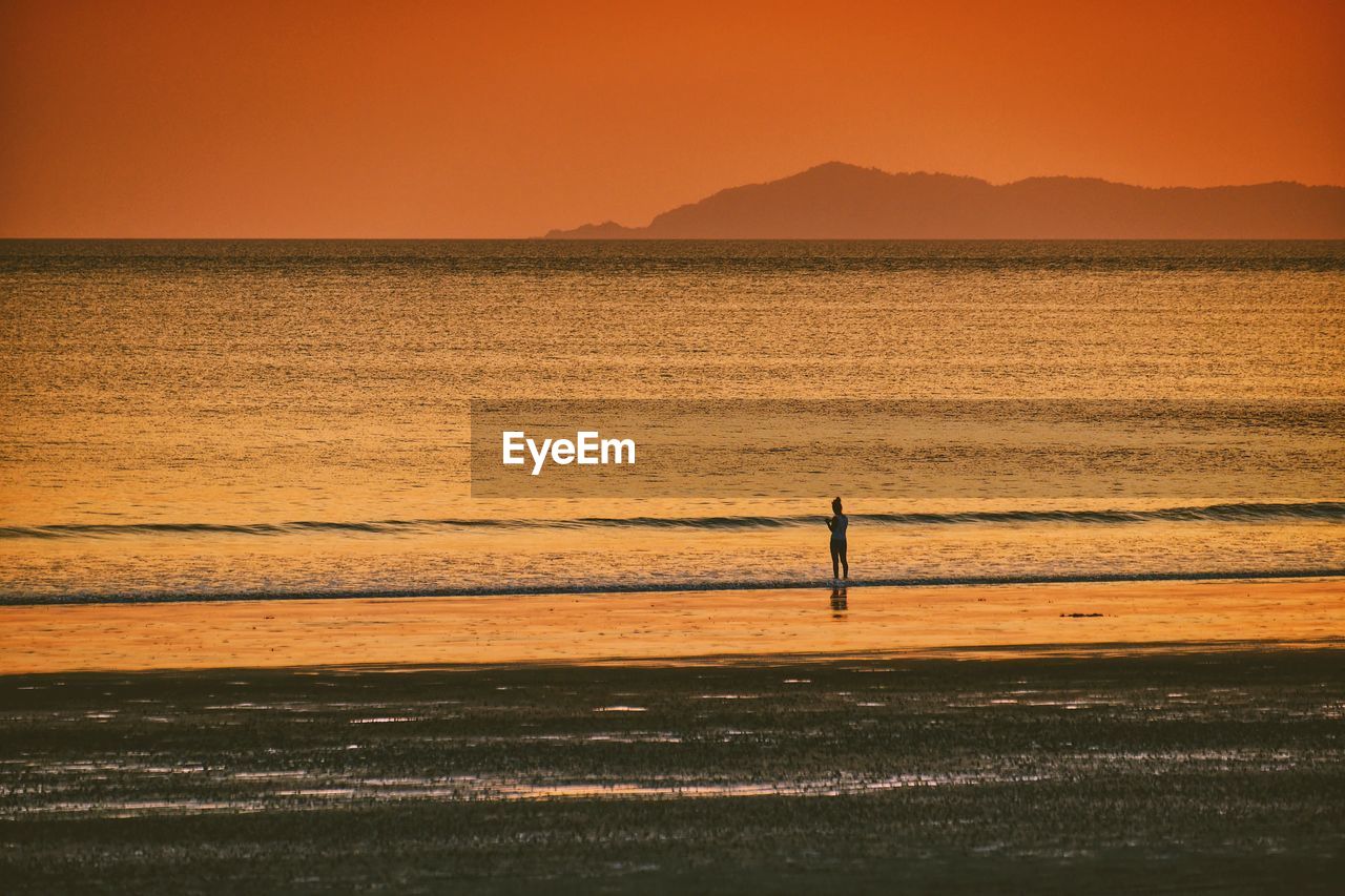 SCENIC VIEW OF BEACH AGAINST SKY DURING SUNSET