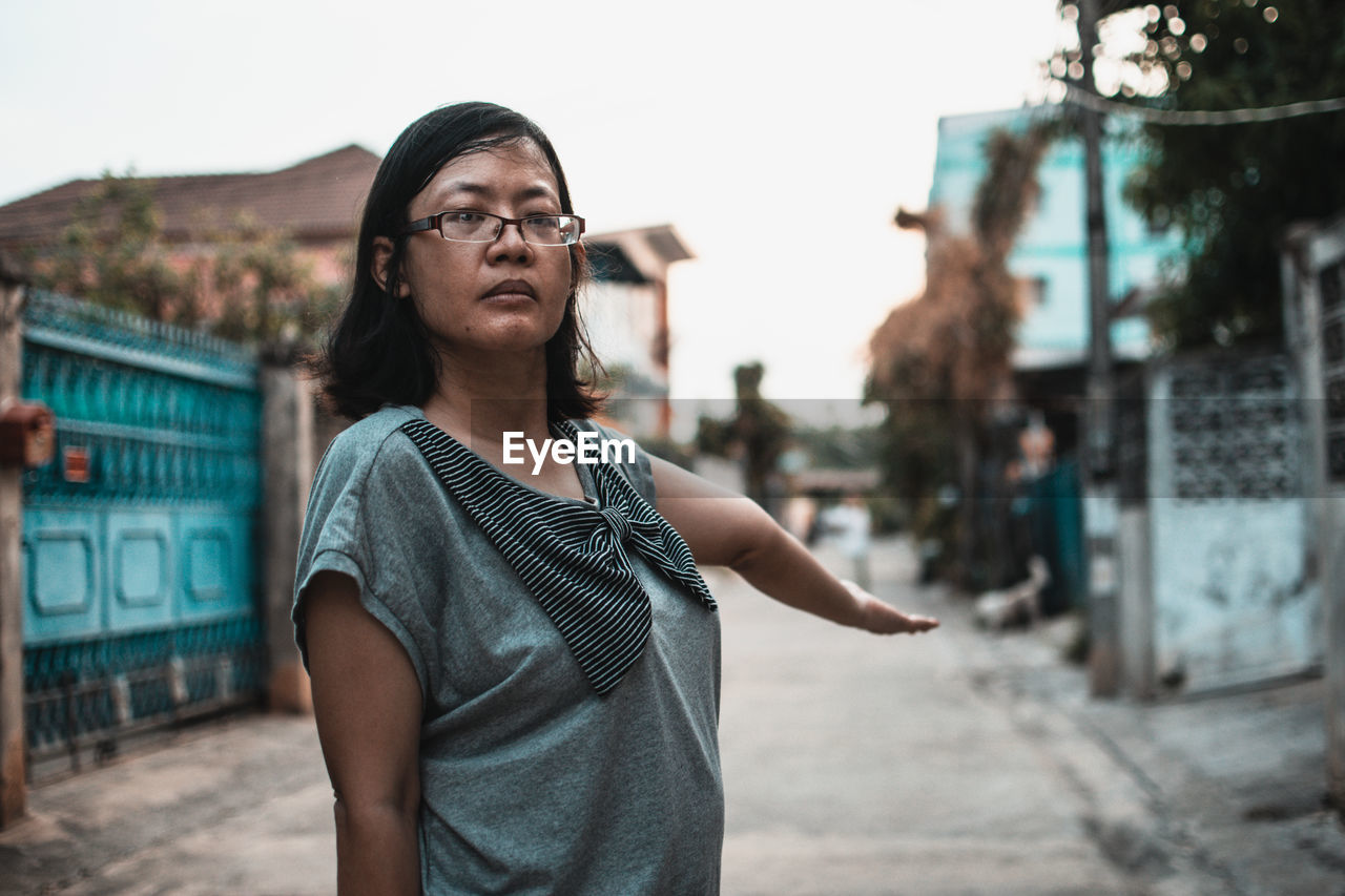 Portrait of young woman looking at city