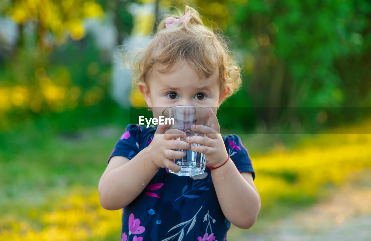 Portrait of cute girl drinking water