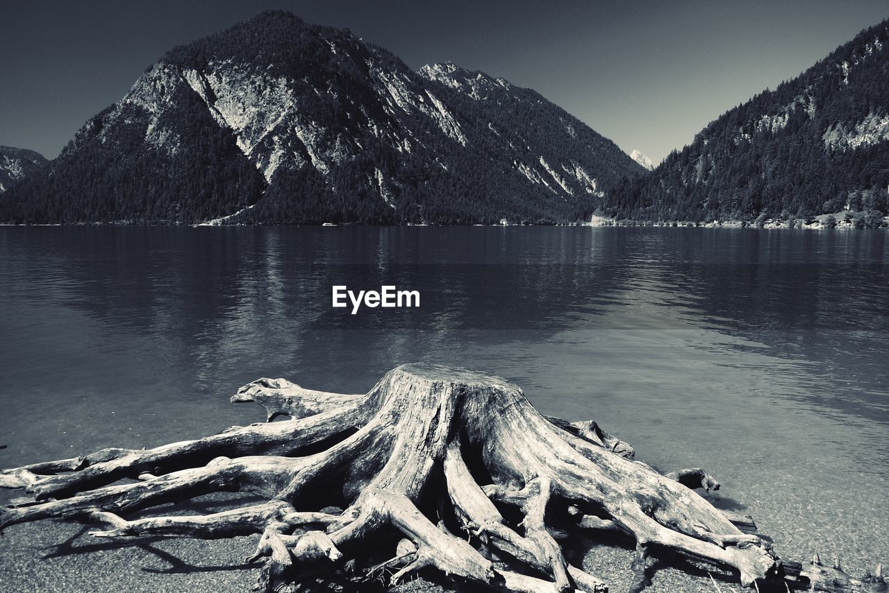 Scenic view of lake by mountains against sky