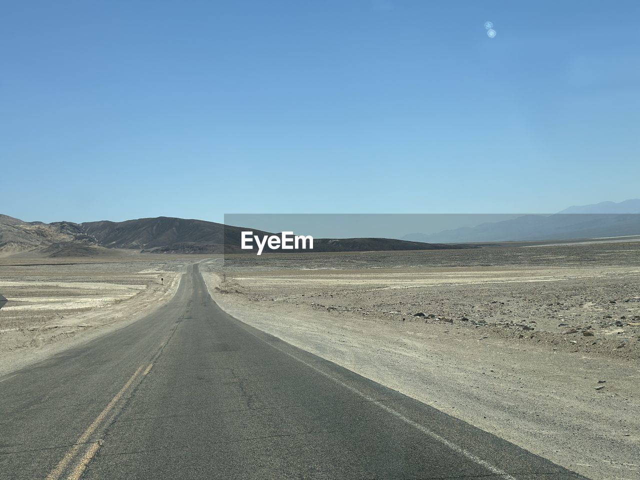 road, sky, transportation, landscape, environment, scenics - nature, horizon, the way forward, desert, natural environment, mountain, nature, land, no people, clear sky, highway, beauty in nature, remote, diminishing perspective, travel, vanishing point, non-urban scene, tranquility, tranquil scene, blue, empty road, road trip, day, horizon over land, arid climate, road marking, plain, mountain range, marking, plateau, travel destinations, journey, outdoors, infrastructure, copy space, empty, asphalt, climate, sunny, symbol, dirt road, sand, barren, absence, country road, semi-arid, physical geography