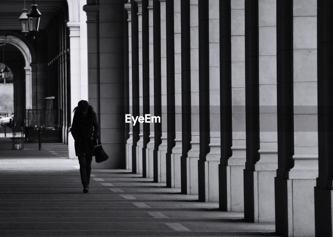 Woman walking against building