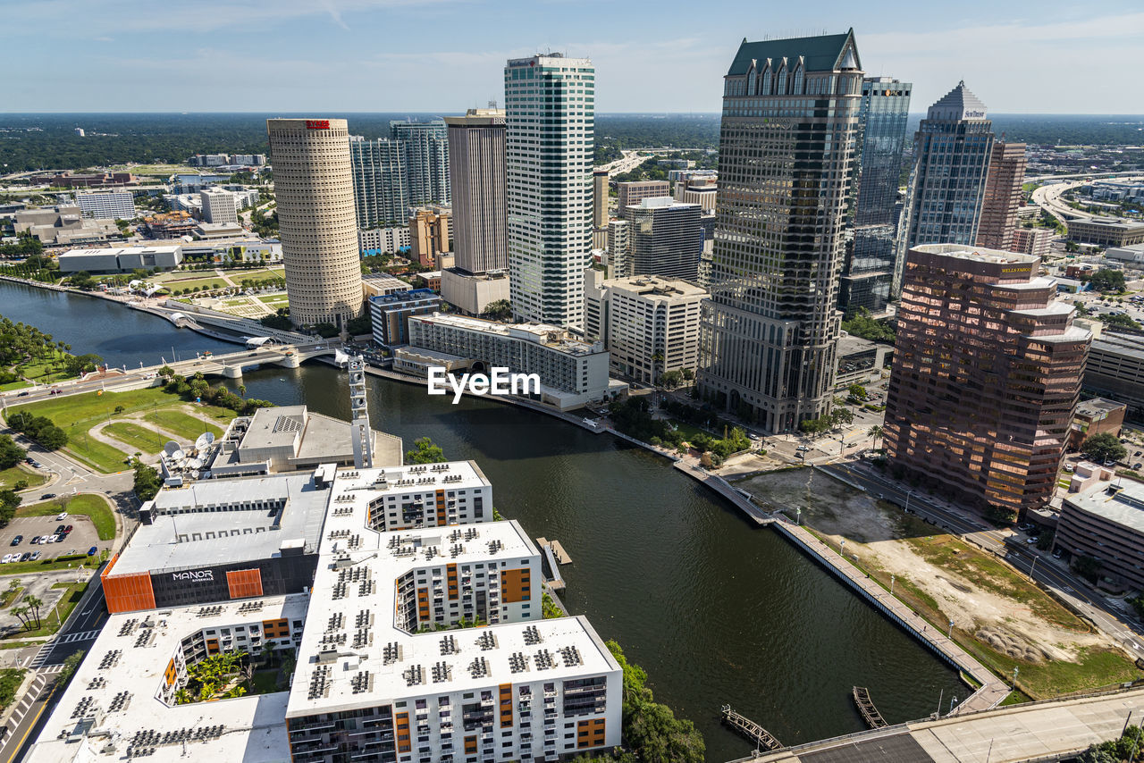 HIGH ANGLE VIEW OF RIVER BY BUILDINGS IN CITY