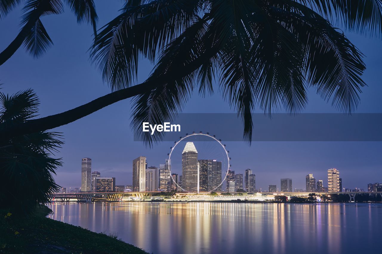 Illuminated modern buildings in city at waterfront