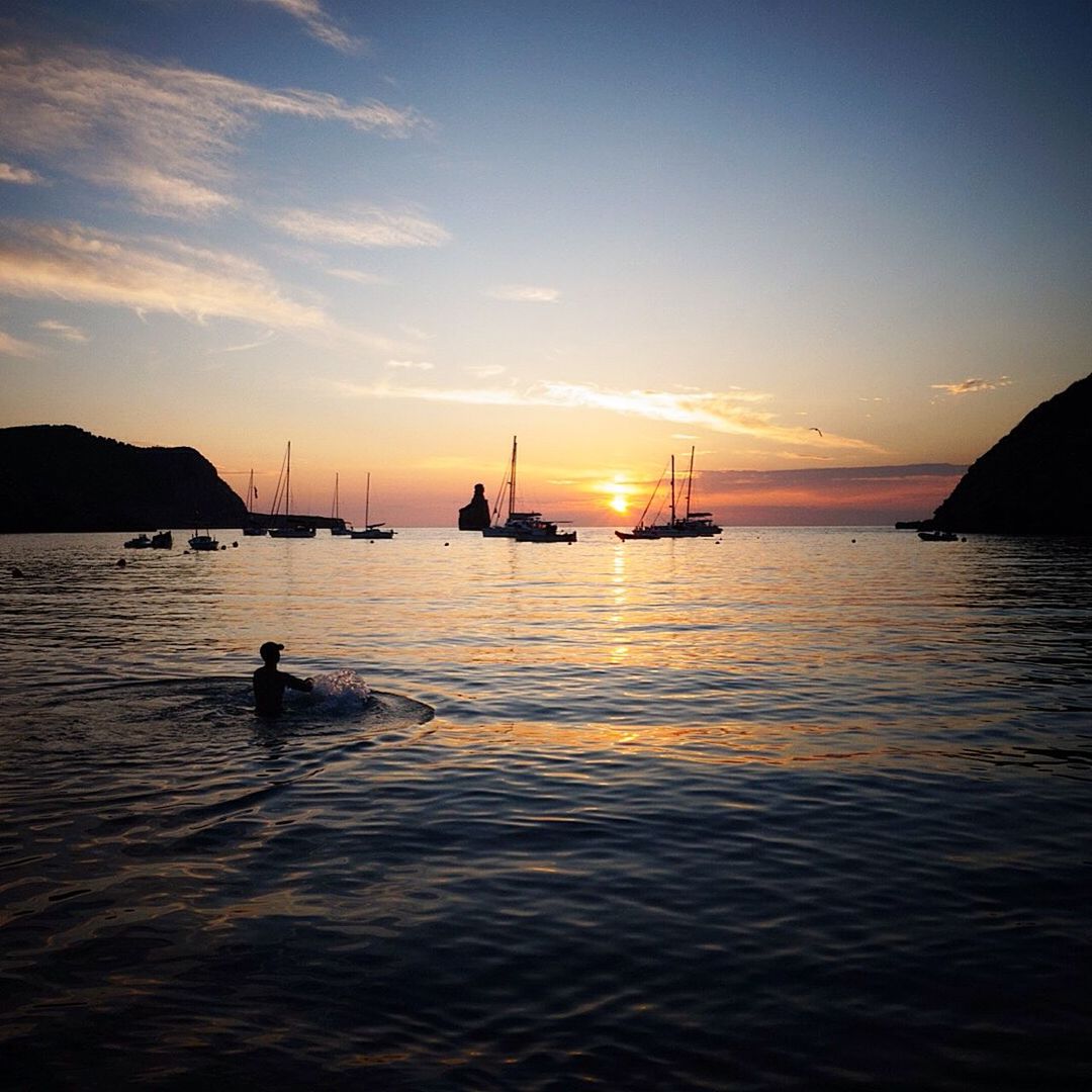 Man swimming in sea at sunset