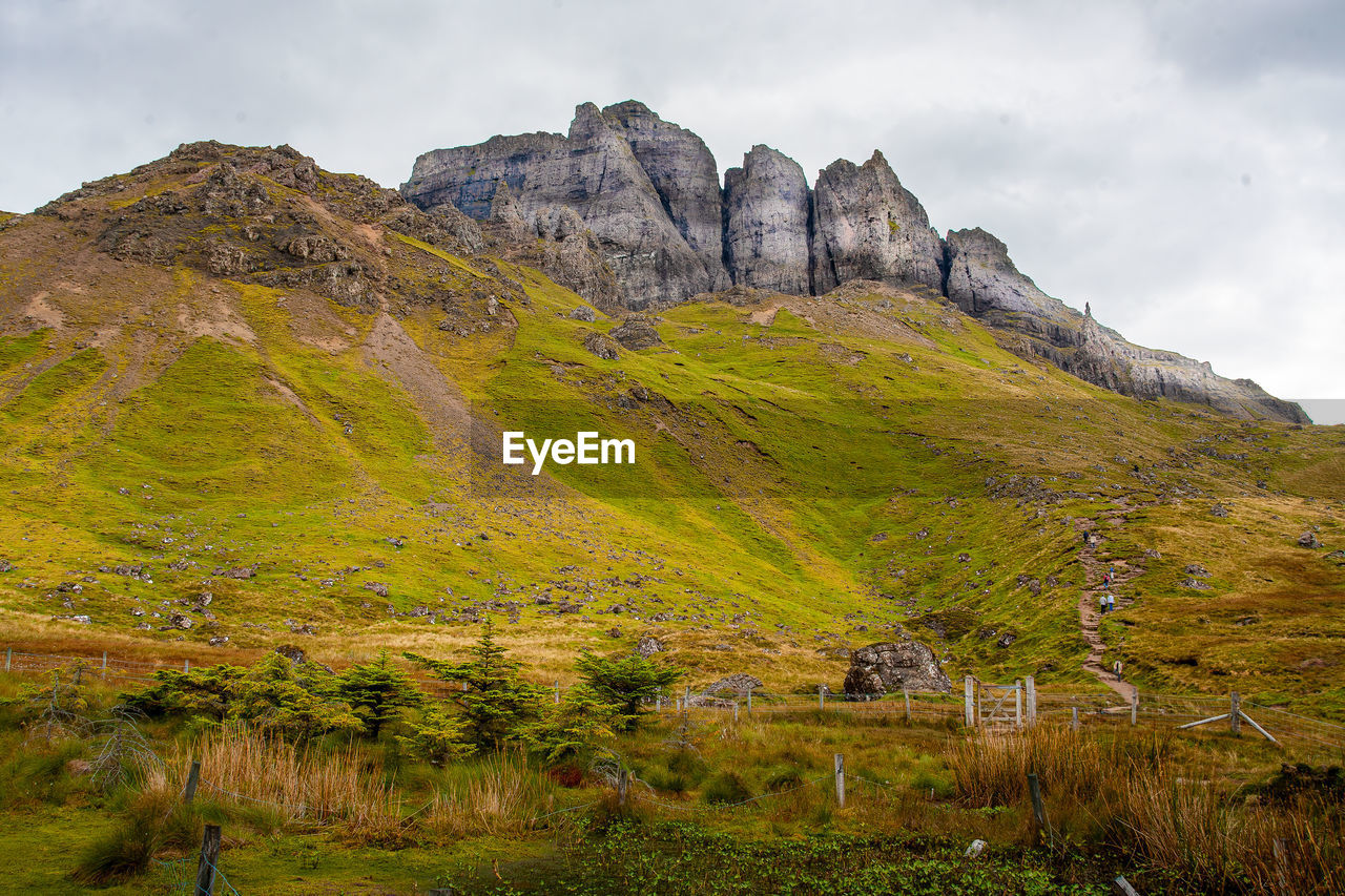 Walking track up to the old man of storr rock formation. isle of skye, scotland. gate in foreground.