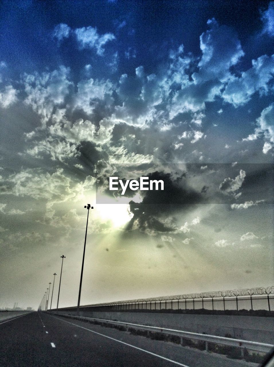 VIEW OF EMPTY ROAD AGAINST CLOUDY SKY