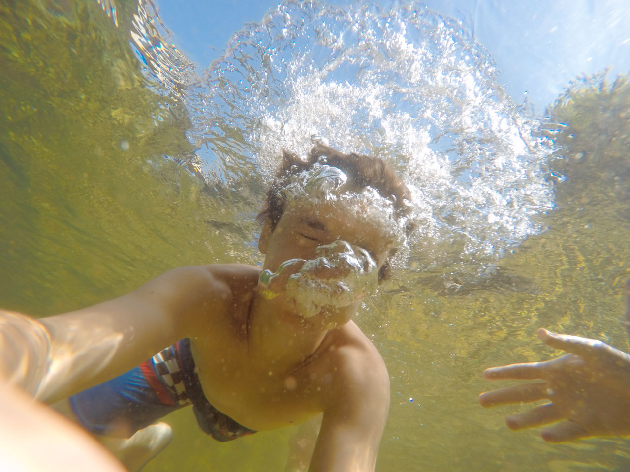 Teenage boy swimming underwater