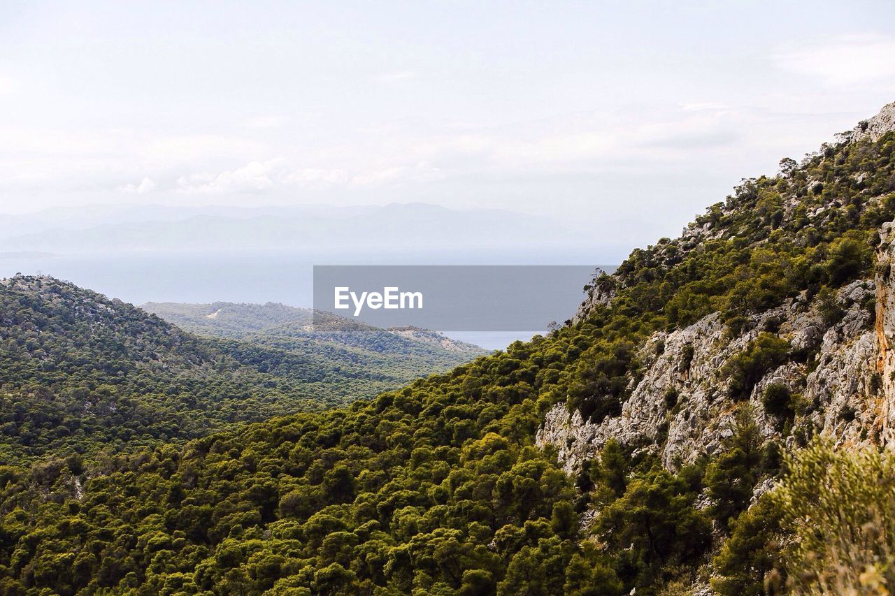 Scenic view of green mountains against sky