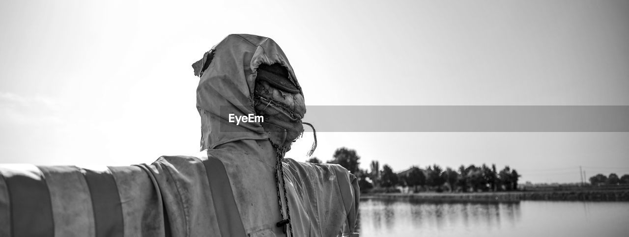 water, black and white, sky, monochrome, monochrome photography, nature, one person, adult, statue, lake, day, rear view, black, copy space, outdoors, clothing, panoramic, reflection, tranquility, person