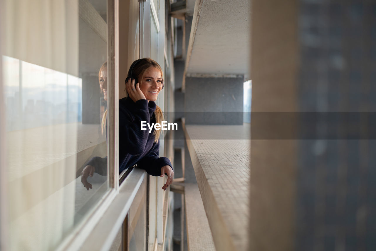 Syoung woman listening to music with headphones, technology, music, urban living, feel good concept.