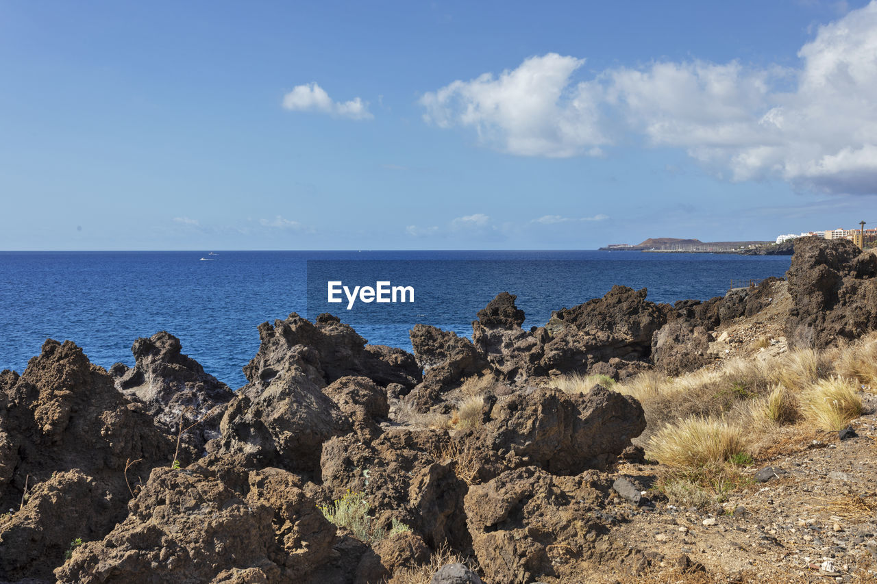 sea, sky, water, land, rock, scenics - nature, beach, nature, beauty in nature, horizon over water, cloud, coast, horizon, shore, ocean, cliff, tranquility, no people, landscape, travel destinations, tranquil scene, body of water, day, environment, blue, travel, terrain, geology, outdoors, coastline, tourism, rock formation, non-urban scene, sunlight, sand, bay