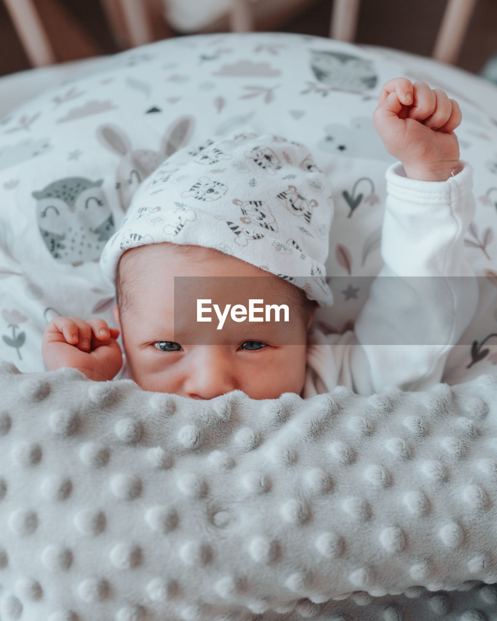 PORTRAIT OF BABY GIRL LYING ON BED