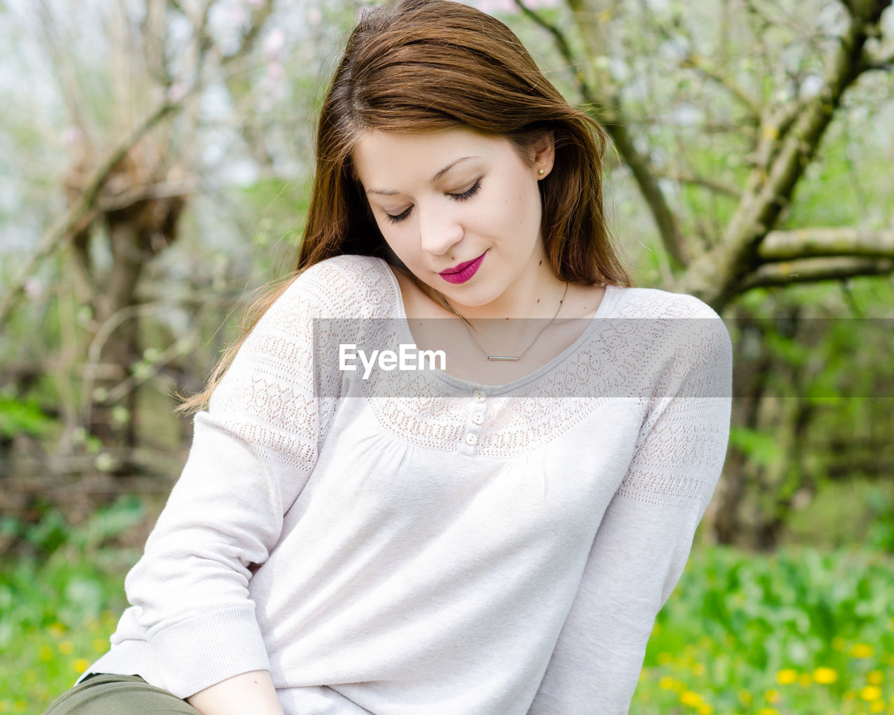 Young woman sitting on field at park