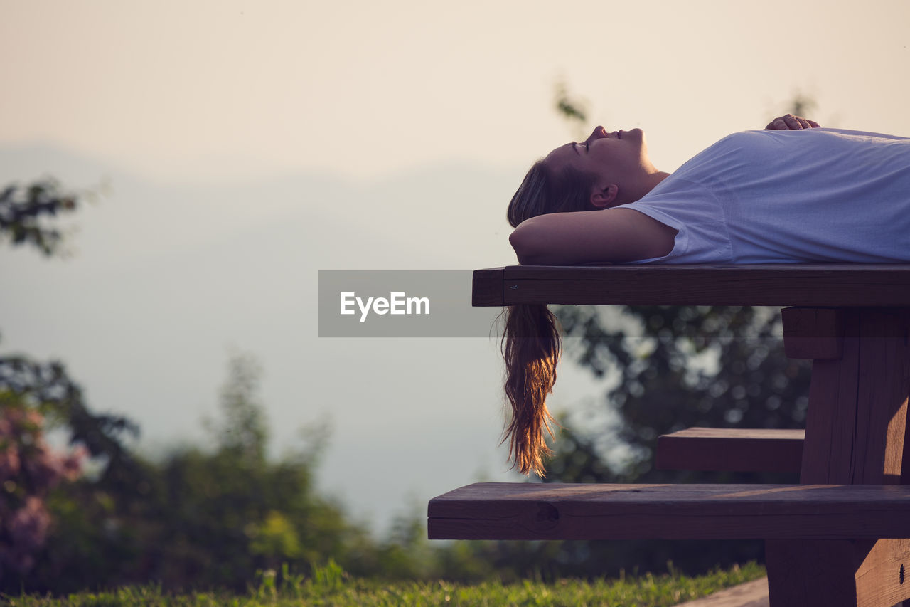 Close-up of woman relaxing on picnic table