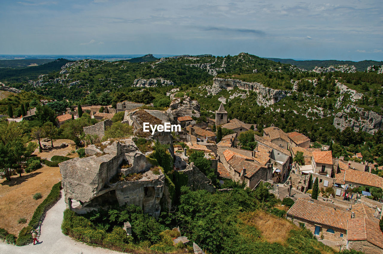 View of the baux-de-provence castle ruins on the hill, with roofs of the village just below, france.