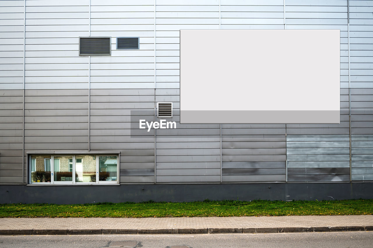 Blank white billboard for advertisement on the facade of building, outdoor advertising mockup