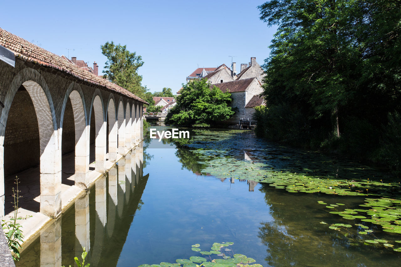 Bridge over river amidst buildings against sky