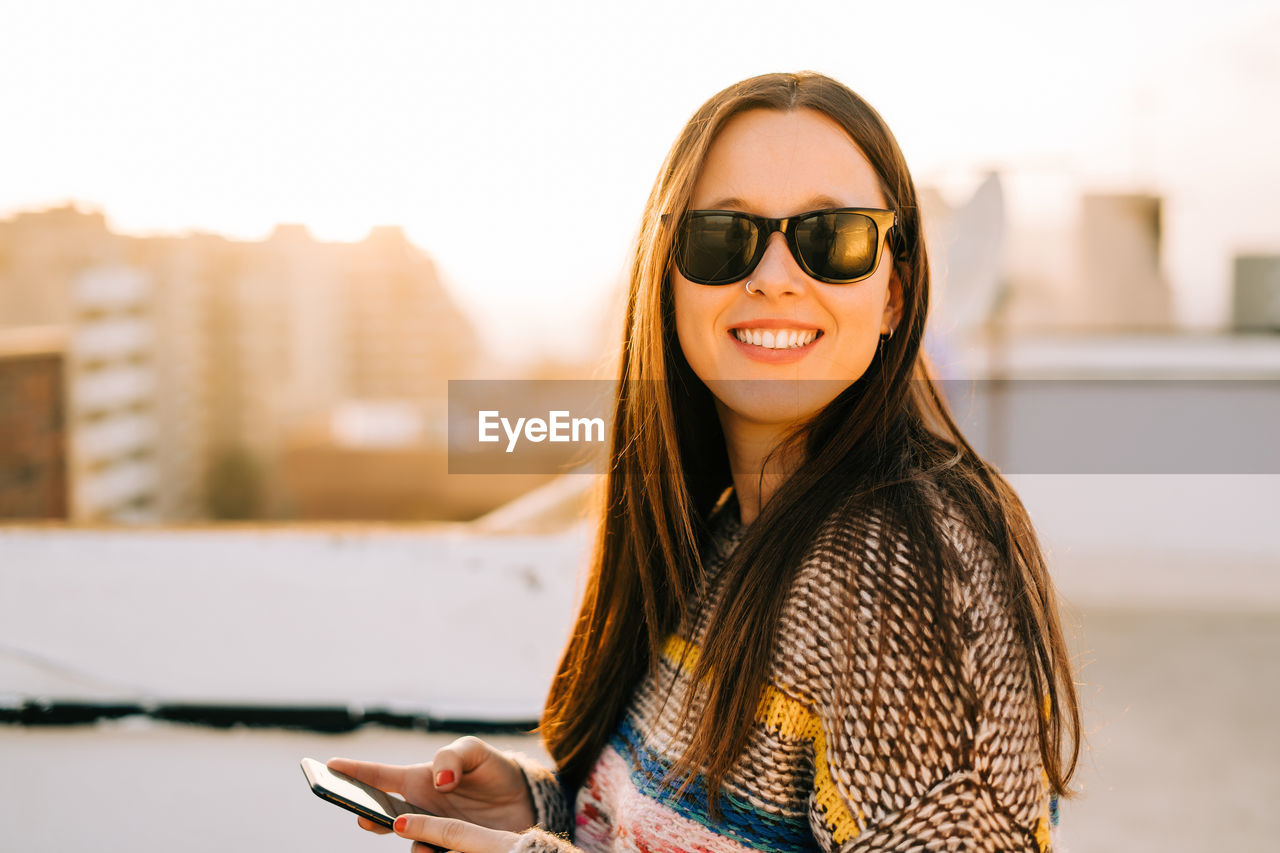 Portrait of smiling woman holding phone 