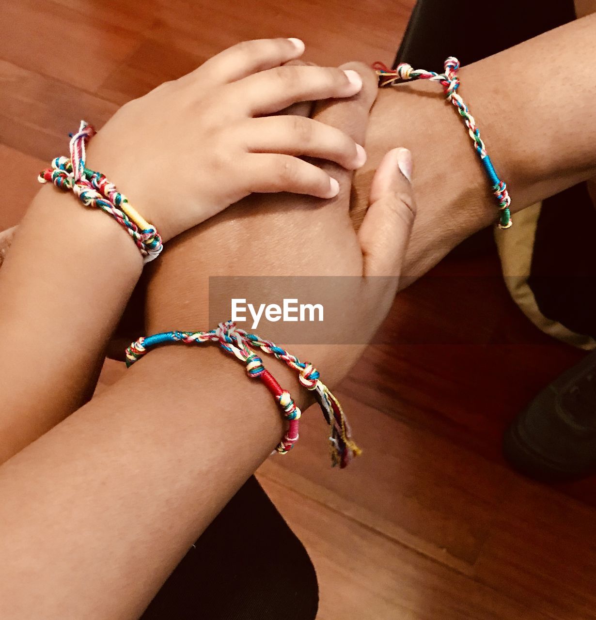 Cropped image of friends stacking hands over on table