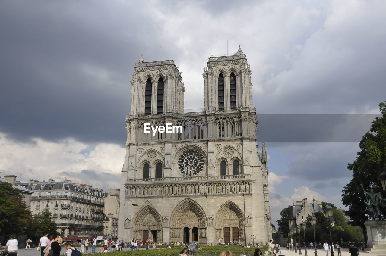 GROUP OF PEOPLE IN CATHEDRAL AGAINST SKY