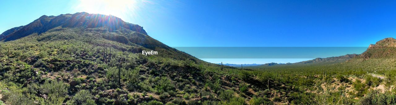 Scenic view of mountains against blue sky