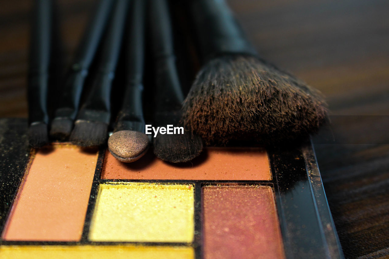 Close-up of face powder and make-up brushes on table