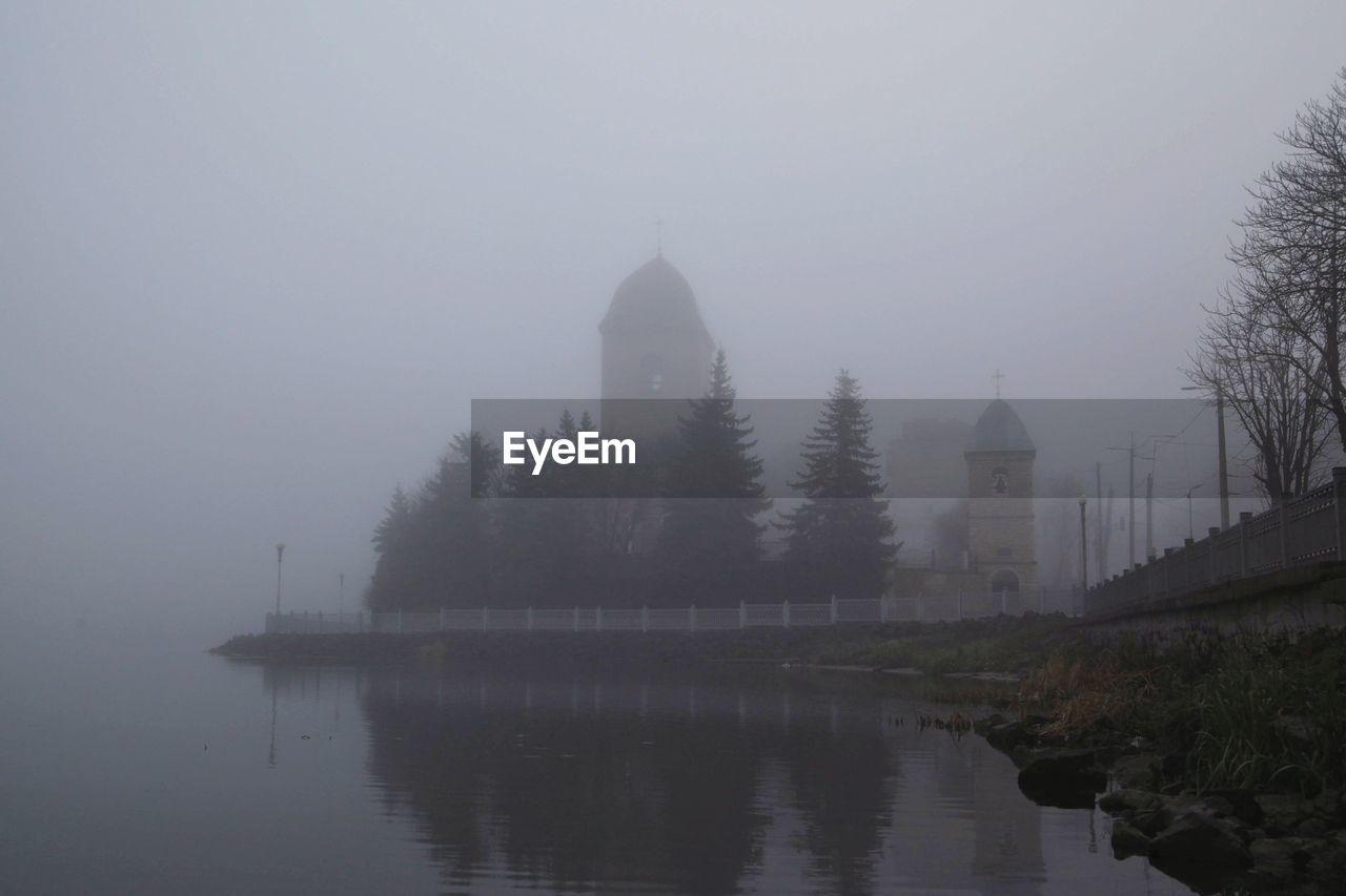 VIEW OF LAKE BY BUILDINGS AGAINST SKY