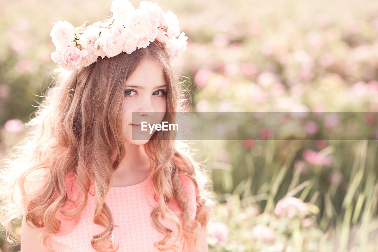 Teenager girl wearing wreath standing at farm