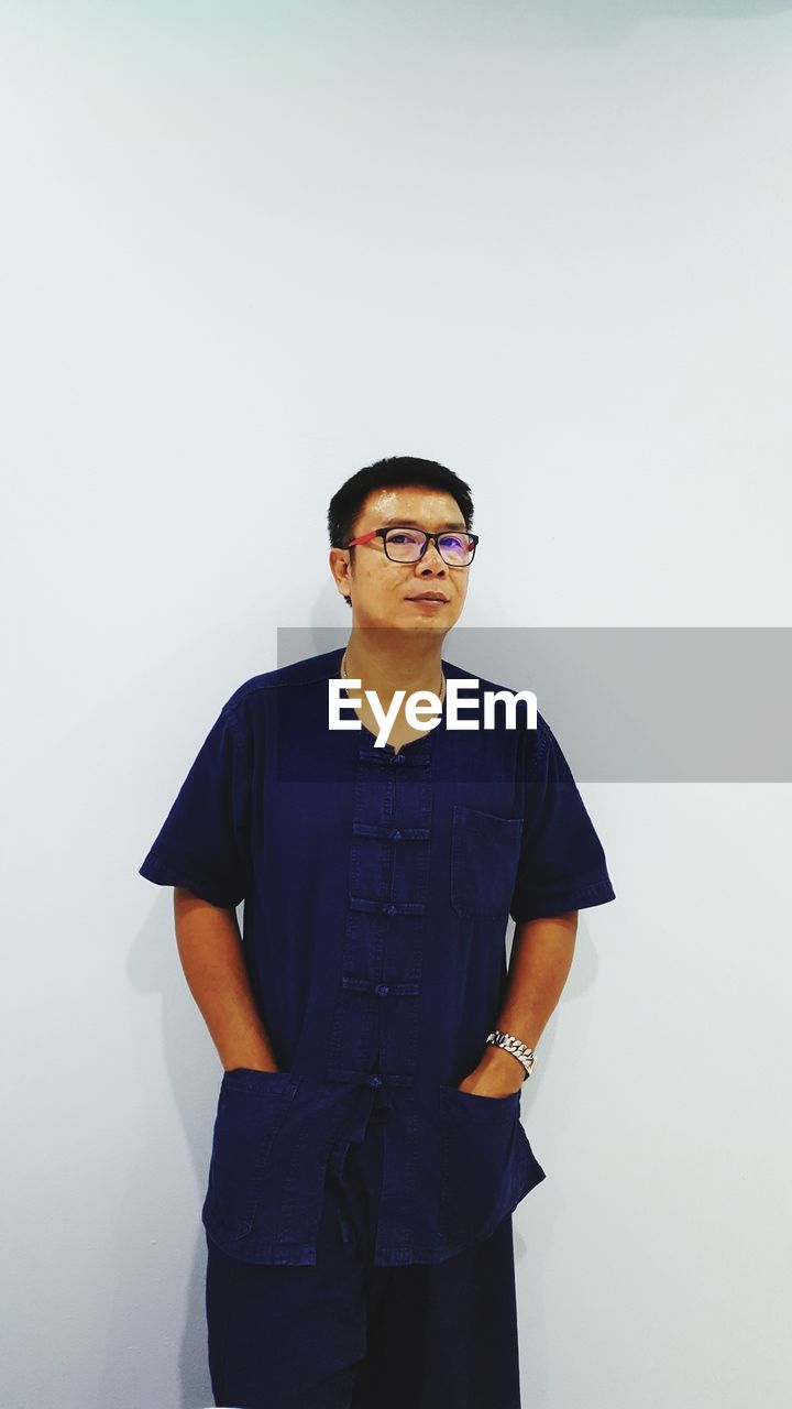 Portrait of man standing against white background