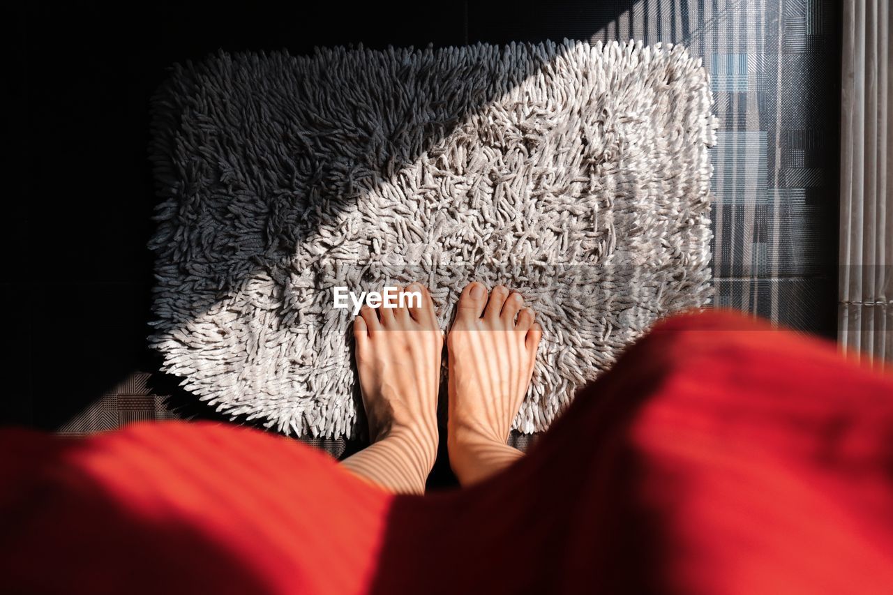 Low section of woman on doormat at home