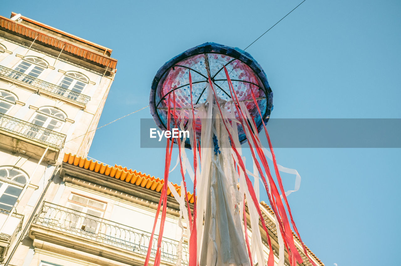 Low angle view of decoration hanging against clear blue sky