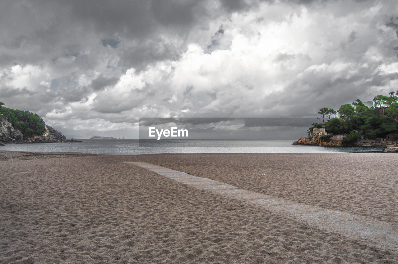 Scenic view of beach and sea against cloudy sky