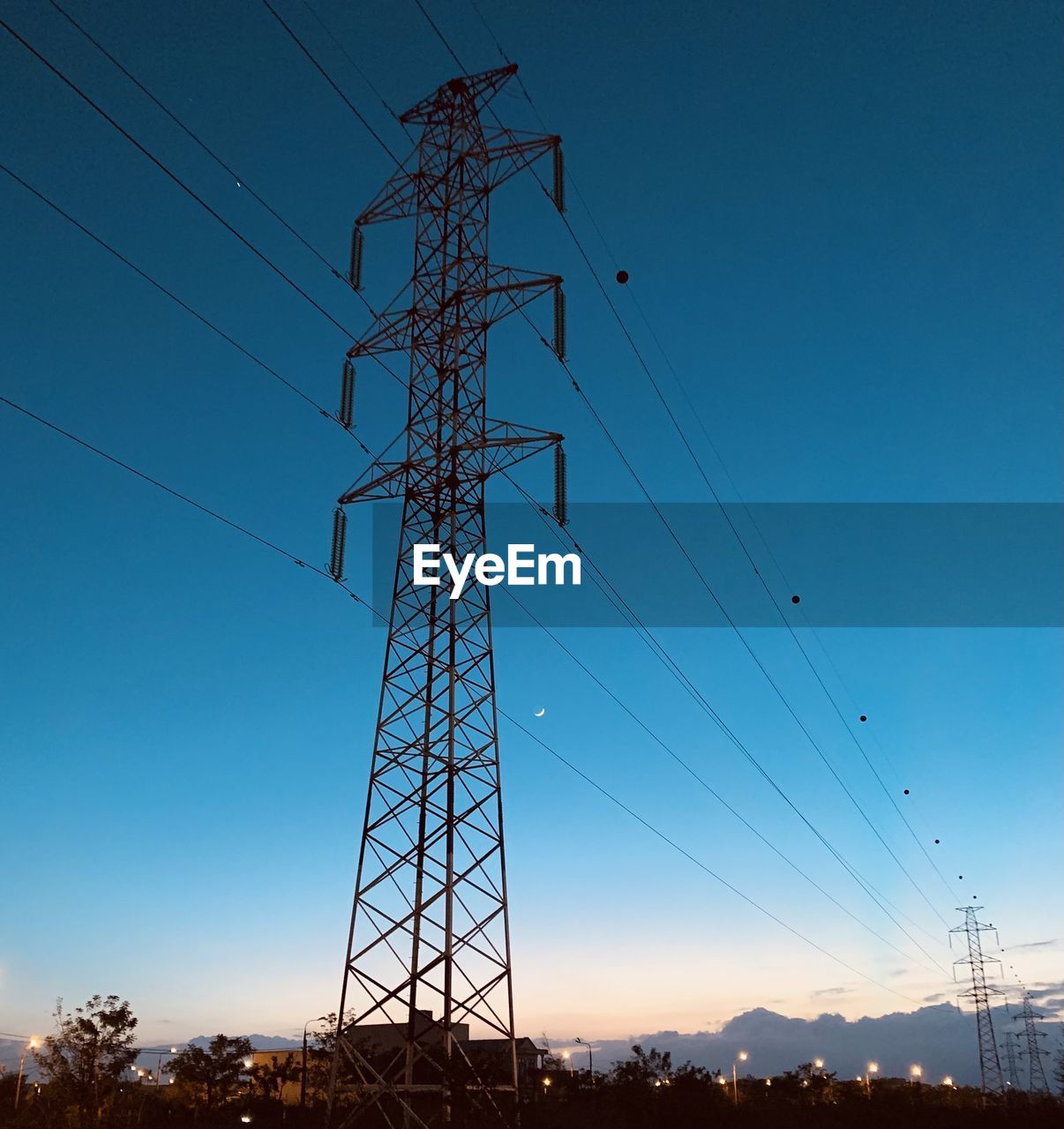 Low angle view of silhouette electricity pylon against clear sky