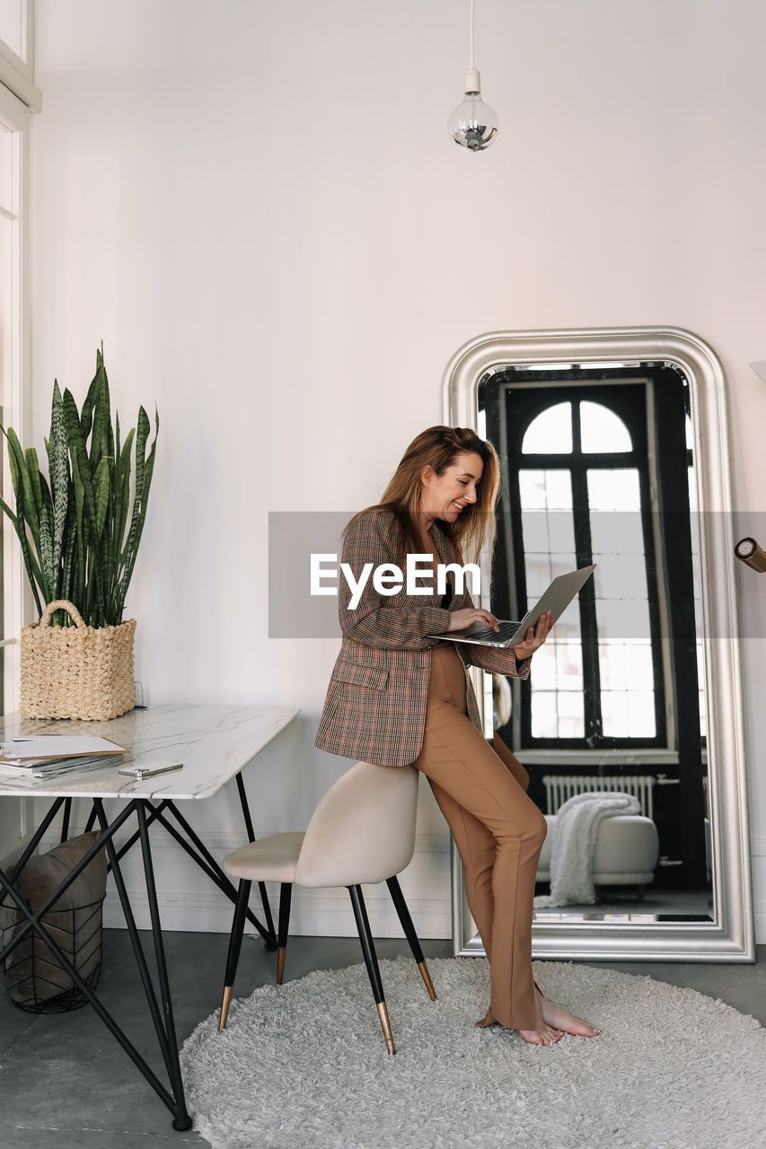 A business woman works online using a laptop phone and technology while sitting in the office