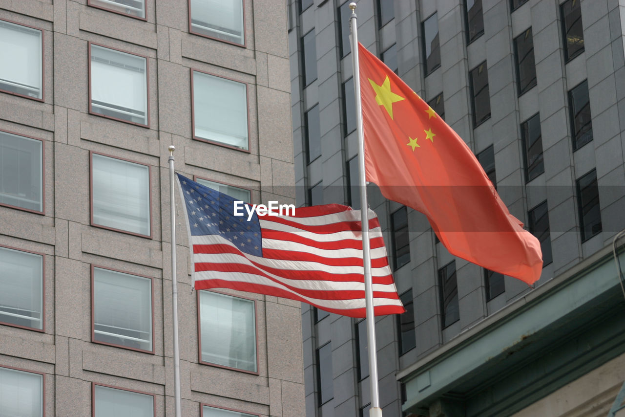 Low angle view of national flags against building in city