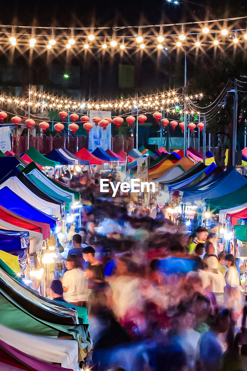 night, illuminated, amusement park, crowd, arts culture and entertainment, fair, group of people, multi colored, large group of people, park, amusement ride, celebration, motion, architecture, amusement park ride, enjoyment, event, lighting equipment, outdoors, city, blurred motion