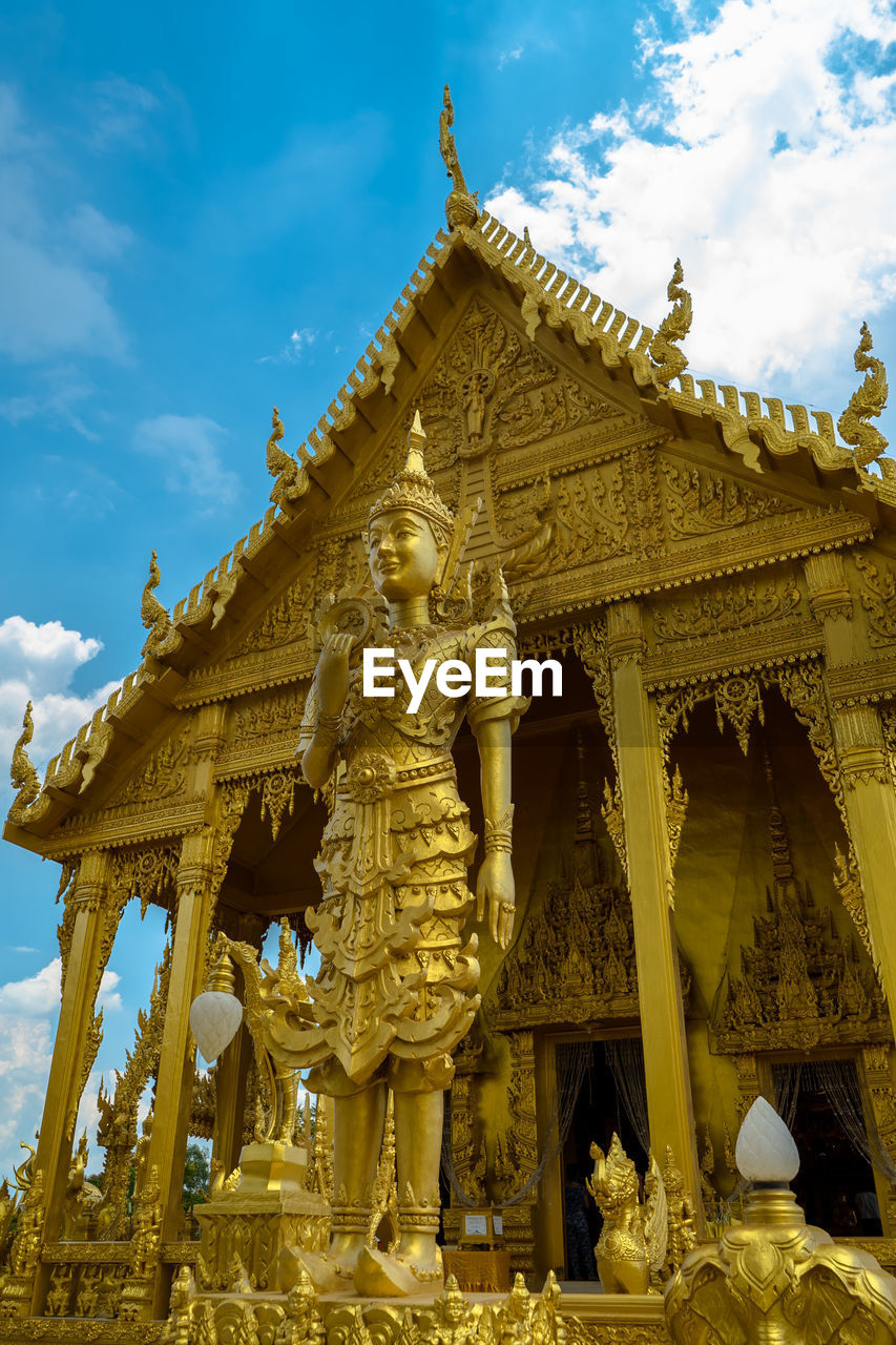 Low angle view of statues outside temple against sky