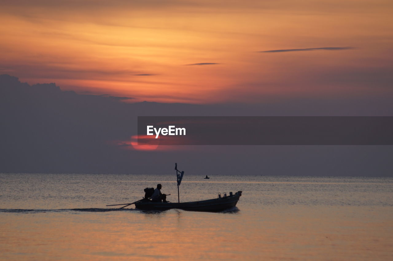 Silhouette boat in sea against sky during sunset