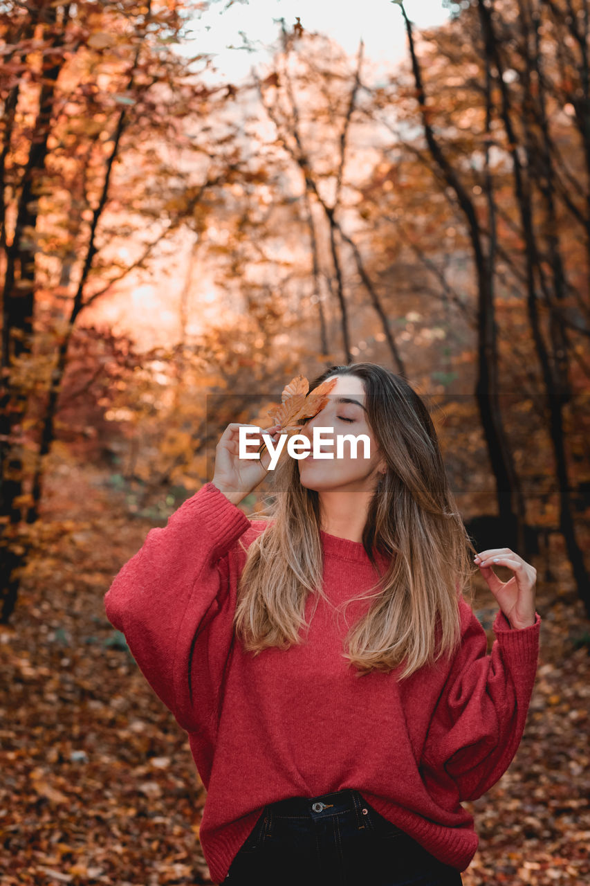 Portrait of beautiful young woman standing on land during autumn