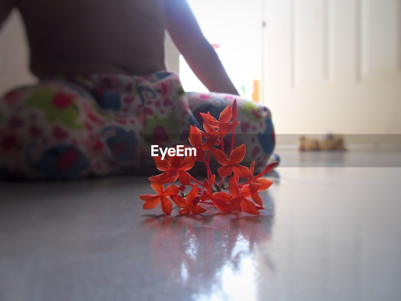 LOW SECTION OF PERSON WITH RED FLOWER ON FLOOR