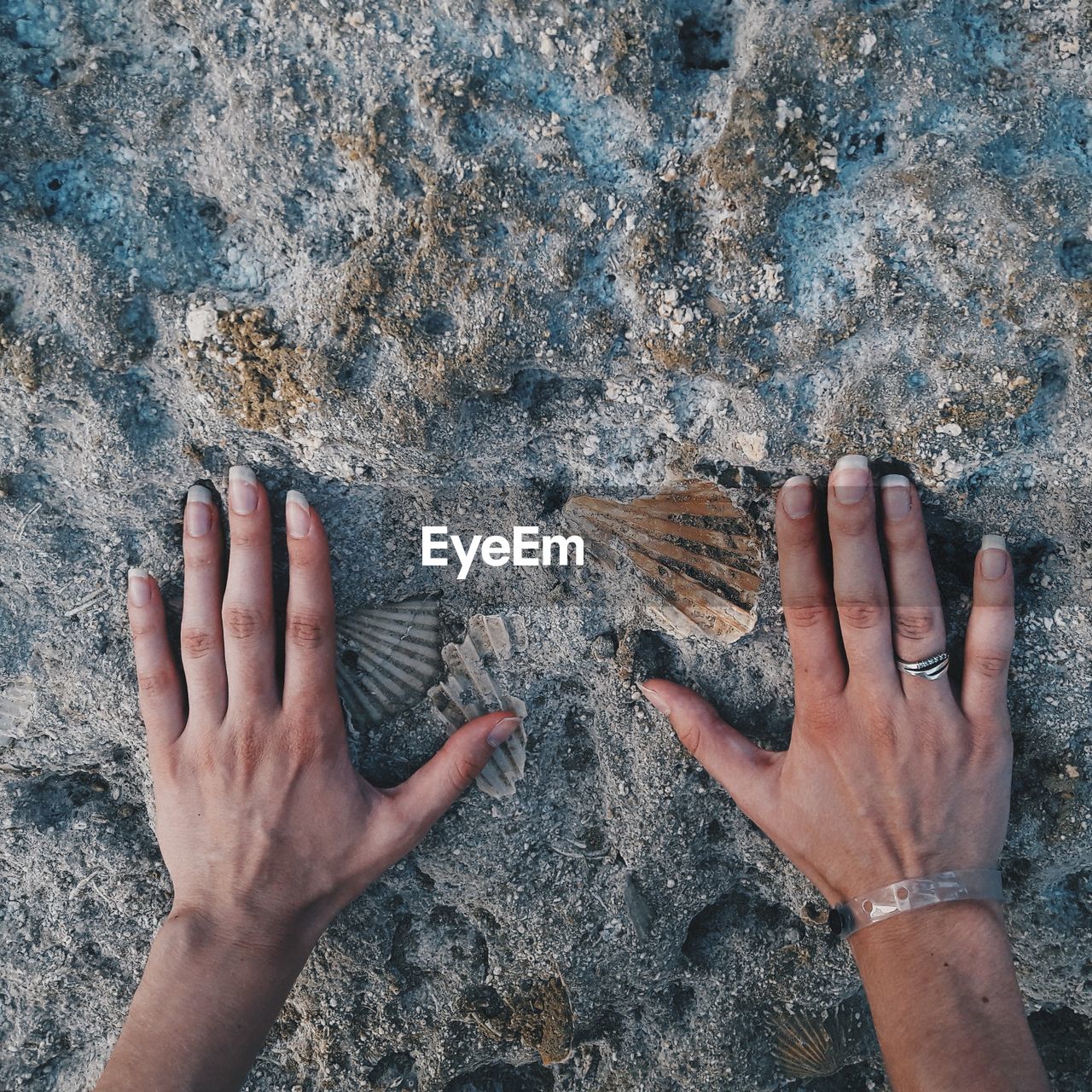 Cropped image of hands touching rock