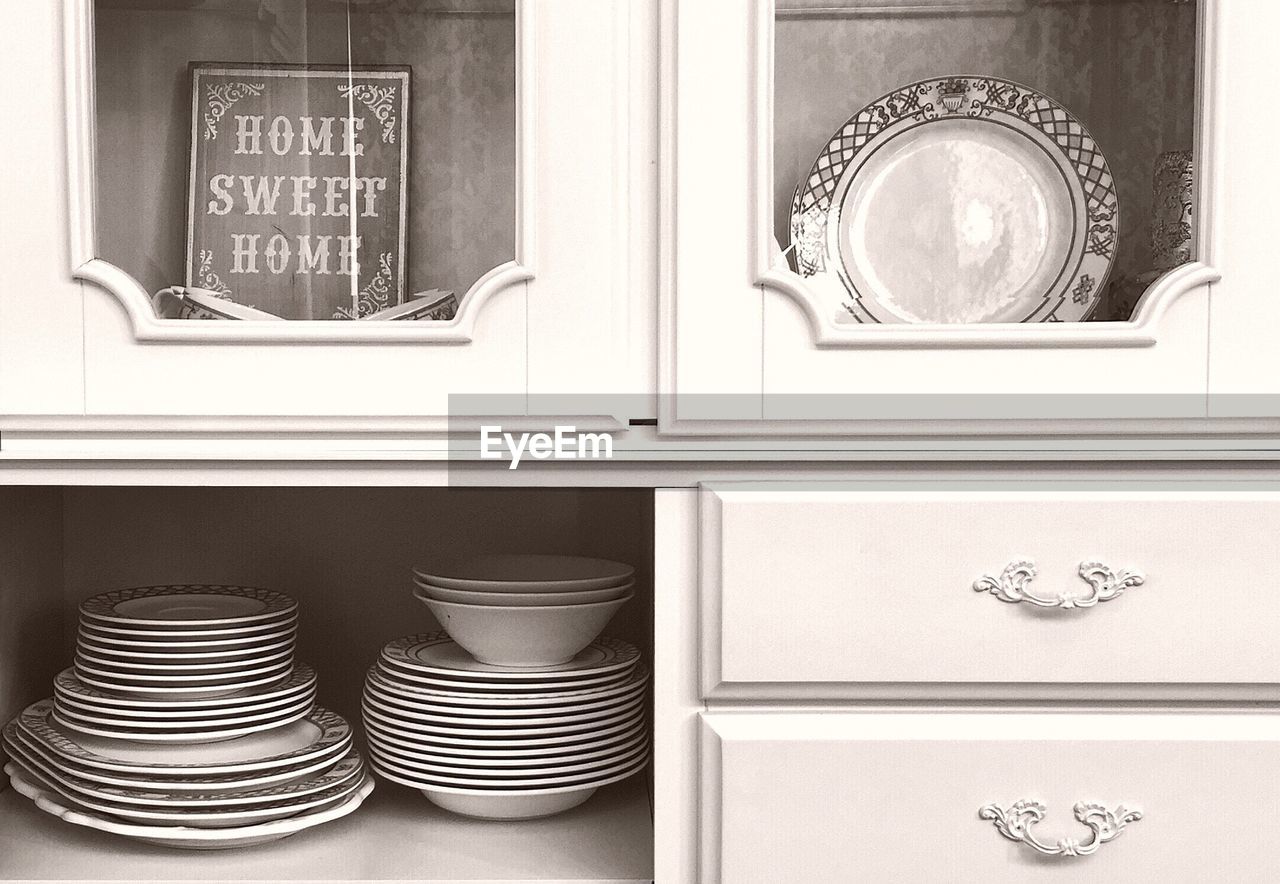 Ceramics arranged in cabinet at kitchen