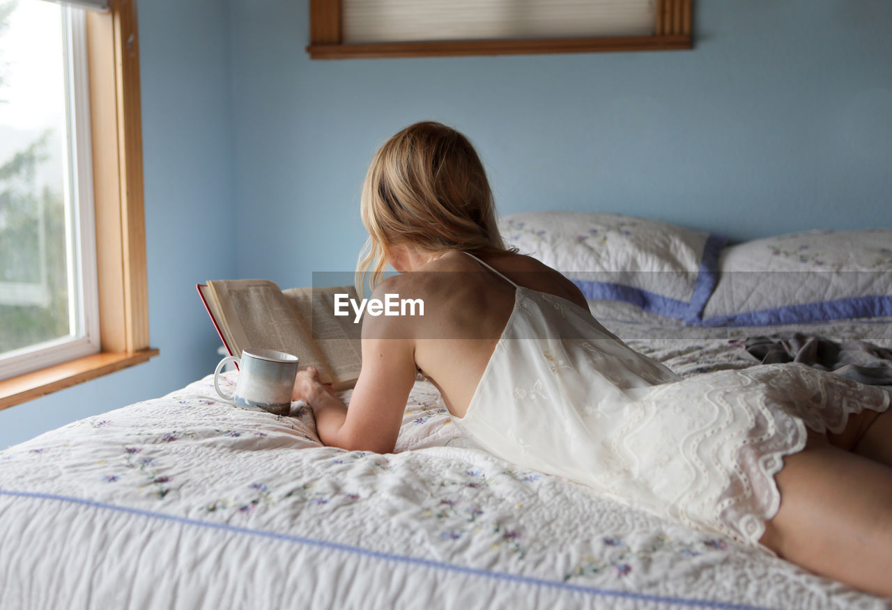 Young woman lying on bed at home