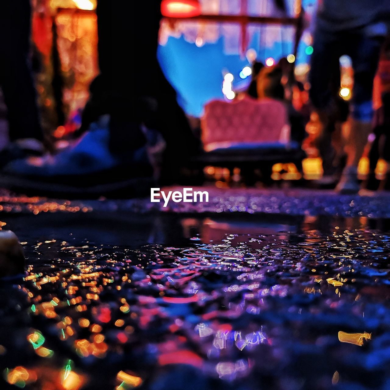 Surface level of wet illuminated street at night