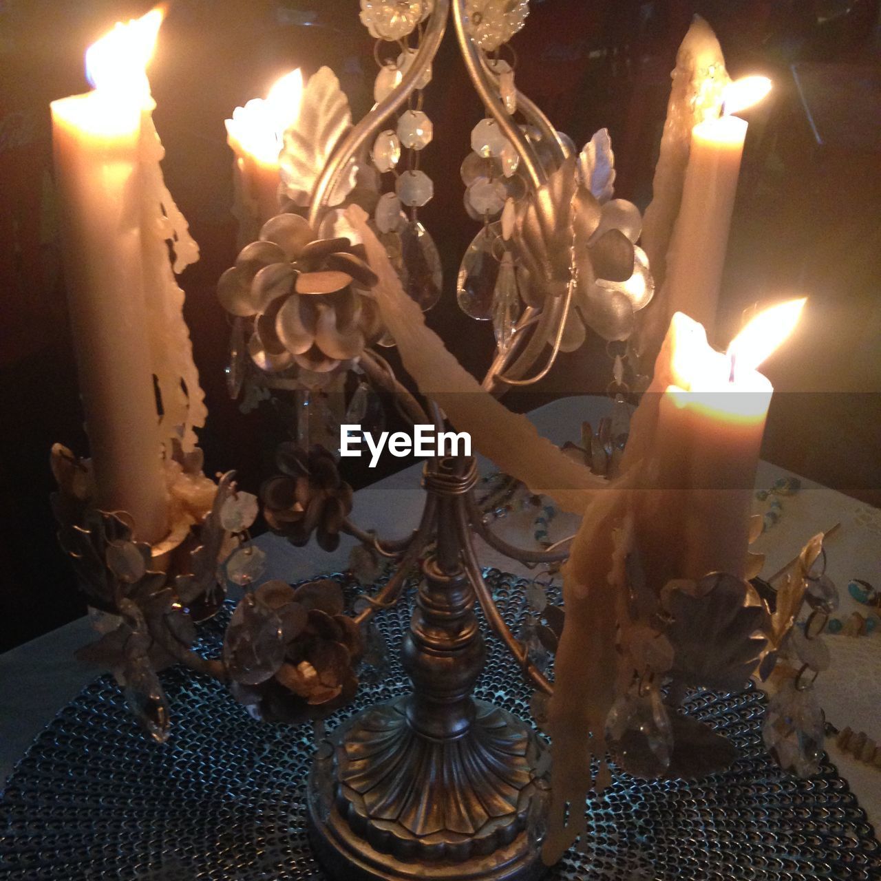 CLOSE-UP OF LIT CANDLE IN DARK ROOM