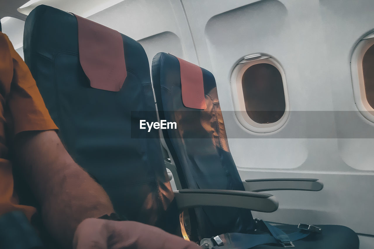 Midsection of man sitting in airplane