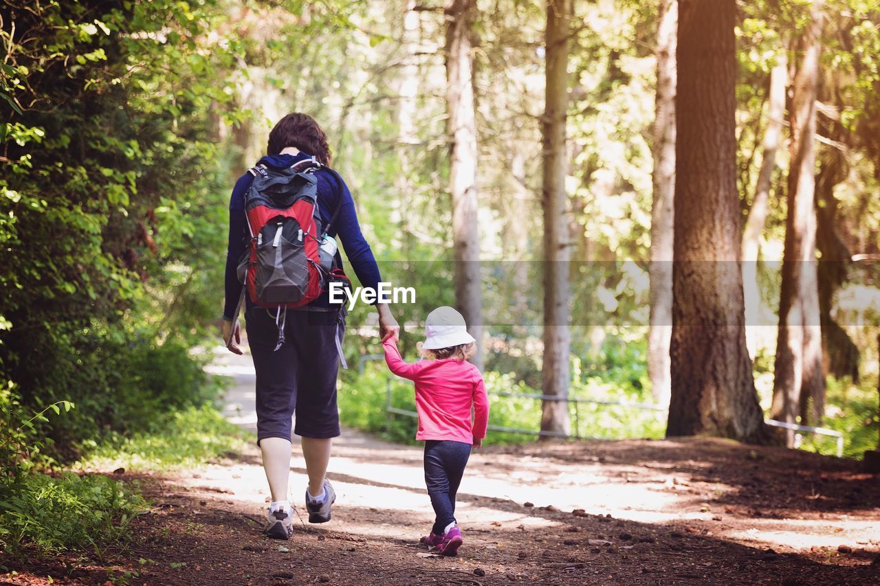 Rear view of mother and daughter in forest