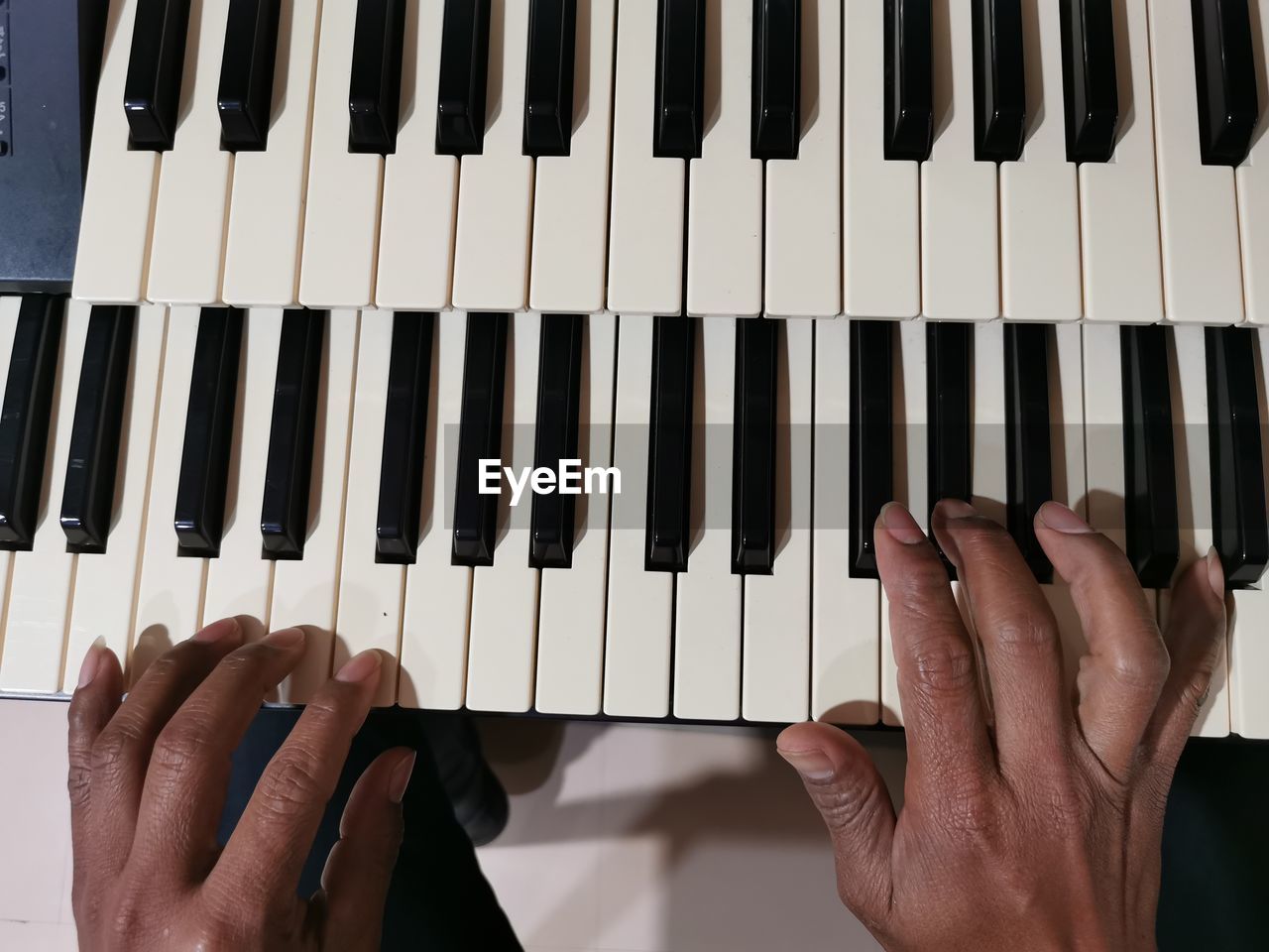 Midsection of person playing piano