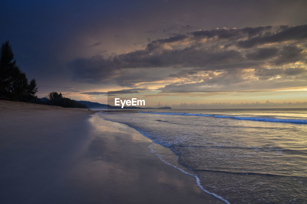 View of beach against cloudy sky